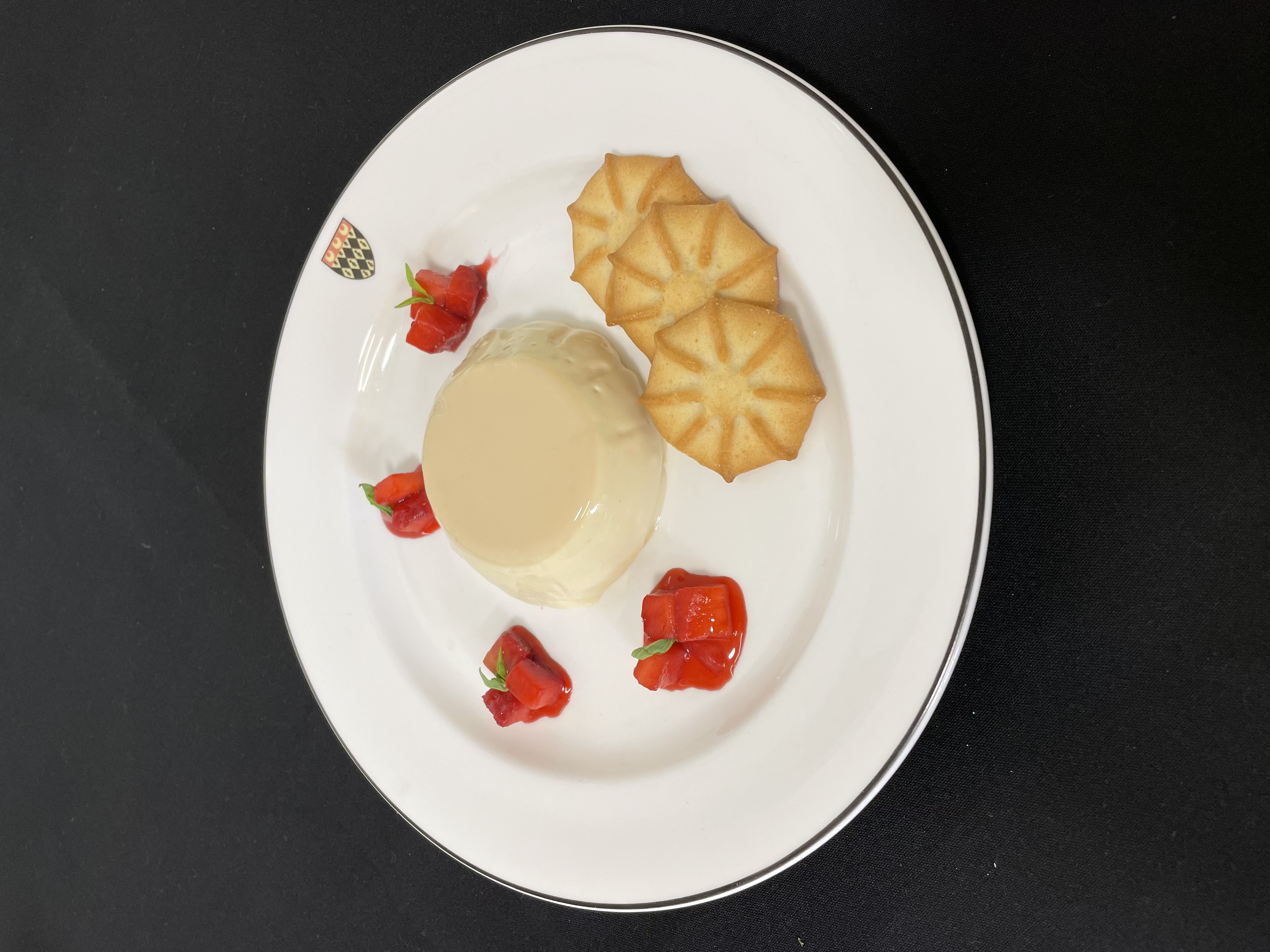 Vanilla panna cotta: served with poached strawberries, shortbread and baby basil