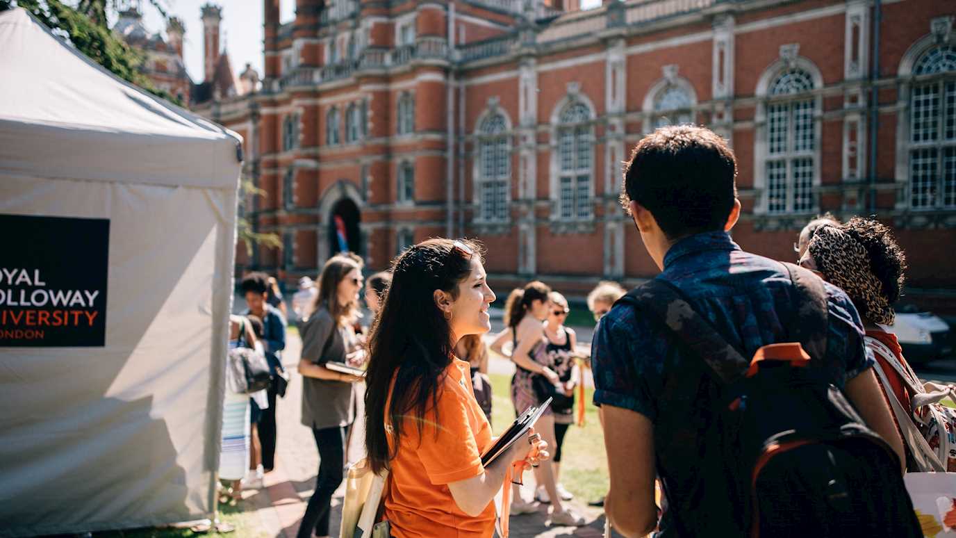 Open Day students registering in front of Founder's, student ambassador, tent, backpack