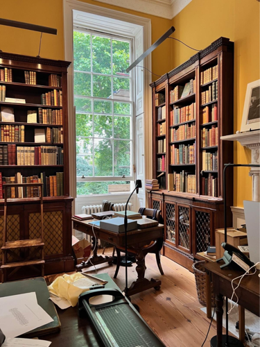 A room with a desk and bookshelves

AI-generated content may be incorrect.