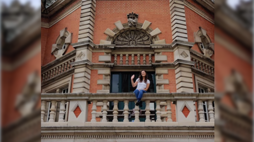 Emma sitting on the balcony at Royal Holloway